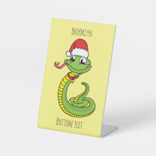 Cute green snake with santa hat cartoon pedestal sign