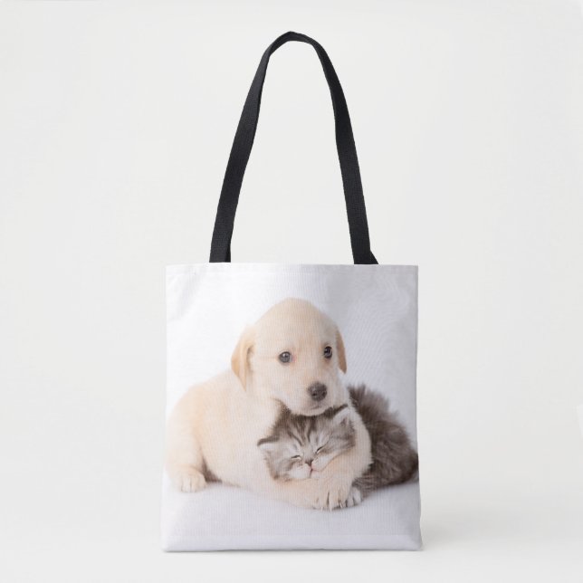 cute little cat sleeps in dog's hands tote bag (Front)