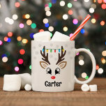 Cute Reindeer Boy Christmas Lights Custom Name Coffee Mug<br><div class="desc">Cute Christmas coffee or hot cocoa mug features an illustration of a sweet Rudolph reindeer boy face with a shiny red nose, eyelashes, and antlers. He is dressed up with a strand of colourful Christmas light bulbs and surrounded by light grey snowflakes. Personalize this festive hot chocolate mug with a...</div>