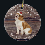 Cute Santa Hat English Bulldog Christmas  Ceramic Ornament<br><div class="desc">This ceramic Christmas ornament has a cute English Bulldog  wearing a red Santa hat ,  wood and lights background and a message from the bulldog on the back. This ornament is perfect for your tree or to give as a gift.</div>
