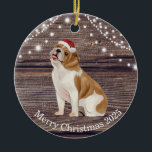 Cute Santa Hat English Bulldog Christmas  Ceramic Ornament<br><div class="desc">This ceramic Christmas ornament has a cute English Bulldog  wearing a red Santa hat ,  wood and lights background and a message from the bulldog on the back. This ornament is perfect for your tree or to give as a gift.</div>