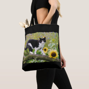 Cute tuxedo cat on a tree branch with sunflowers - tote bag