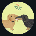 Dachshunds Mistletoe Kiss | Christmas Wiener Dogs Classic Round Sticker<br><div class="desc">A cute Dachshund lover’s Christmas sticker,  great for sealing gifts this holiday season. Black and tan longhaired Doxie and red shorthaired Dachshund kiss under the mistletoe. An original cartoon weenie dogs art illustration by ©Jenn Inashvili. Visit Jenn’s Doodle World for some original gifts featuring this adorable dogs design.</div>