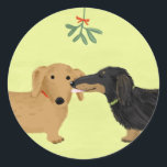 Dachshunds Mistletoe Kiss | Christmas Wiener Dogs Classic Round Sticker<br><div class="desc">A cute Dachshund lover’s Christmas sticker,  great for sealing gifts this holiday season. Black and tan longhaired Doxie and red shorthaired Dachshund kiss under the mistletoe. An original cartoon weenie dogs art illustration by ©Jenn Inashvili. Visit Jenn’s Doodle World for some original gifts featuring this adorable dogs design.</div>