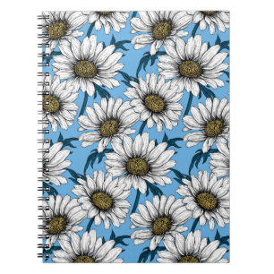 Daisies, wild flowers on blue notebook