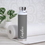 Dark Grey Personalized Wedding Bridesmaid Water Bottle<br><div class="desc">Gift your wedding bridesmaid or maid of honour with this trendy, vacuum Insulated water bottle that features her name in white, stylized script on a dark grey colour background designed to match your wedding colour scheme. Personalize bottle by editing and replacing name with your own as desired. Select your water...</div>