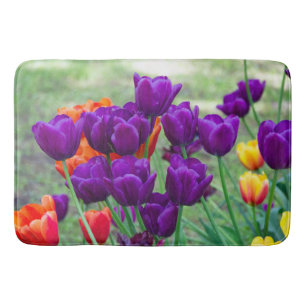 Dark purple tulips  on a sunny day in the garden   bath mat