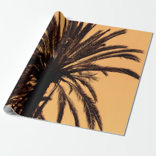 Dark silhouettes of date palms against bright colo wrapping paper