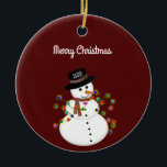 Dated Merry Christmas Snowman Personalized Ceramic Ornament<br><div class="desc">Cute snowman is tangled with lit Christmas lights, has the year on his hat - The "Merry Christmas" text above can be changed or added to, and the font style/size can also be changed. Shown on a deep red background, which can be changed to any colour you prefer. The ornament...</div>