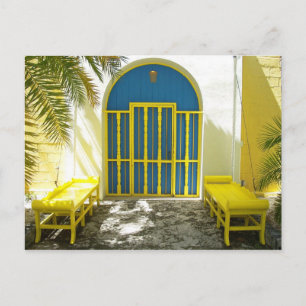 Decorated blue door with yellow benches postcard