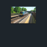 Deighton Railway Station, Huddersfield Canvas Print<br><div class="desc">This dynamic photo captures a TransPennine Express train as it speeds through Deighton Railway Station in West Yorkshire. The clear blue sky and lush green trees highlight the classic British railway scene, making it a perfect piece for trainspotters, commuters, and lovers of UK transport. A fantastic addition to any product,...</div>