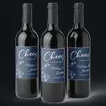 Delicate orchids cheers to the wedding blue custom wine label<br><div class="desc">Elegant customizable wine labels for your wedding reception, featuring beautiful and delicate white orchids line drawing on one side, over a classic Prussian blue background, and the wording "Cheers to the wedding of" in white fonts. Easily edit the template fields to add the bride and groom names in a classy...</div>