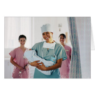Delivery room nurse holding baby, nurses in