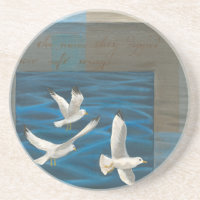 Trois mouettes blanches volent au-dessus de l'eau