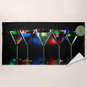 Different cocktails in martini glasses with lights beach towel