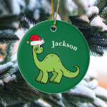 Dinosaur Christmas Cute Custom Kids Green Ceramic Ornament<br><div class="desc">Awesome green dinosaur smiling and looking very cute in a holiday red Santa Claus hat. Customize this adorable children's Christmas ornament gift with the recipient's name to make it even more personalized. Cool little boy present for a kid.</div>