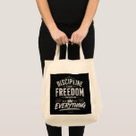 Discipline Today Freedom Tomorrow Tote Bag<br><div class="desc">A bold and powerful typography design set on a deep black background with distressed white lettering. This eye-catching composition combines vintage and street-style elements, featuring layered fonts, ornamental details, and a strong motivational message. The mix of classic serif typography and rough brush-style text creates a dynamic and modern look that...</div>