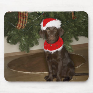 Dog sitting by a Christmas tree Mouse Pad
