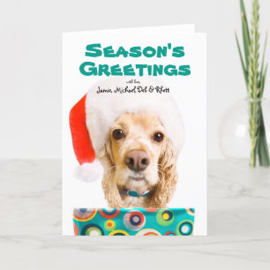 Dog wearing santa hat, holding present holiday card