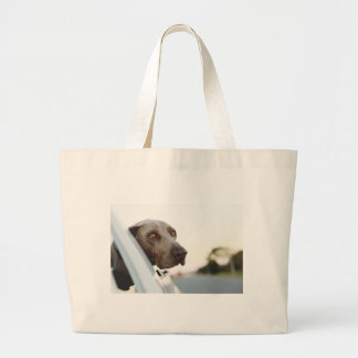 Dog with head out of a car window large tote bag