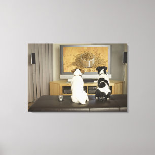 Dogs watching dog dish with food on TV Canvas Print