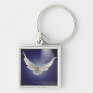 Dove flying through beam of light keychain