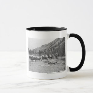 Driving pack mules across a river mug