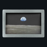 Earth from Moon in Black Space: Earthrise Belt Buckle<br><div class="desc">From the desolate lunar plains, Earth hangs like a fragile ornament in the abyss. The stark contrast between the sterile greys of the moonscape and the vibrant blue marble of Earth ignites a pang of foreignness within the moon. Countless nights it had witnessed Earth dominate the sky, a constant companion....</div>