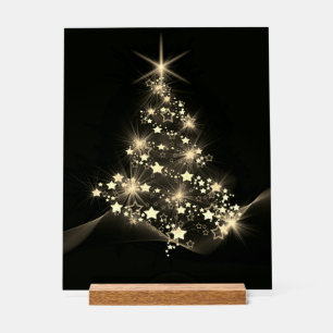 Éclat doré des étoiles sur l'arbre de Noël sombre 
