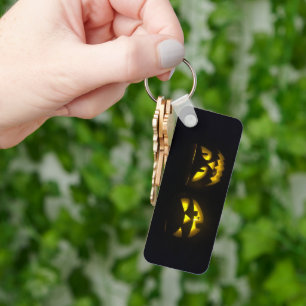 Eerie yellow glow pumpkin faces on black long keychain