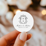 Elegant Black Chinoiserie Crest Monogram Wedding Classic Round Sticker<br><div class="desc">Enhance your wedding details with our Elegant Black Chinoiserie Monogram Crest wedding stickers. Featuring a beautiful black baroque-style crest surrounding the couple's monogram, these stickers display names in classic black calligraphy with the wedding date below. Perfect for sealing envelopes, decorating party favours, and adding a personalized touch to your celebration....</div>