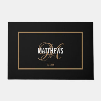 Elegant black gold script monogram name wedding doormat