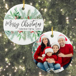 Elegant Botanical Greenery Photo Merry Christmas  Ceramic Ornament<br><div class="desc">This simple and classic round Christmas ornament features elegant greenery on the front, including evergreen branches, soft leaves, and subtle pops of red holly berries for a festive touch. In the centre, “Merry Christmas” is written in graceful script typography, with space below for your family name or business name. The...</div>