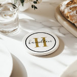 Elegant Brass Black Round Custom Monogram Initial Coaster<br><div class="desc">Elegant round personalized beverage drink coaster design features a classic custom serif monogram initial in antique gold / brass with your last name in modern black calligraphy script against a clean white background. A simple black circle frames the design. Colour scheme can be customized to coordinate perfectly with your home...</div>