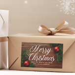 Elegant Company Merry Christmas Modern Custom Gift Sticker<br><div class="desc">This classy company Christmas gift sticker features elegant white cursive typography over a beautiful holiday photograph. The photo features red ornaments and green mistletoe bordering a wood floor. This upscale corporate Christmas present label features your business name on the front and custom company message inside.</div>