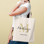 Elegant Gold Black Custom Wedding Bridesmaid Name Tote Bag<br><div class="desc">Elegant custom wedding tote bag features a personalized monogram typography design with modern calligraphy script name and serif monogram initial in rich gold and black colours. Includes custom text for a bridal party title like "BRIDESMAID" or other preferred wording.</div>