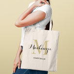 Elegant Gold Black Monogram Bridesmaid Tote Bag<br><div class="desc">Timeless glamour meets classic elegance with this tote featuring a gold monogram initial layered with a personalized name in sophisticated black script and the bridal party role below. A luxe monogram keepsake with a warm golden glow that elevates any wedding celebration. Name,  initial,  and role are fully customizable.</div>