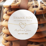 Elegant Gold Wedding Thank You Sticker<br><div class="desc">Add a touch of elegance to your wedding favours with this classic round thank you sticker. Featuring a minimalist gold script with a heart-shaped rope design and personalized names,  it’s the perfect way to thank your guests in style. Ideal for cookie bags,  boxes,  or custom wedding favours.</div>