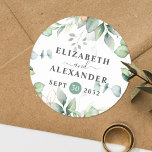 Elegant greenery eucalyptus names and wedding date classic round sticker<br><div class="desc">This romantic and elegant floral wedding round sticker makes the perfect seal for your wedding favour, presenting a chic botanical design that features a classy bouquet of light and airy watercolor greenery and eucalyptus leaves complemented with glittery golden speckles (printed) and is easily customizable with your names and wedding date....</div>