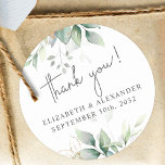 Elegant greenery eucalyptus names and wedding date classic round sticker<br><div class="desc">These romantic and elegant floral Thank you stickers make the perfect seal for your wedding favour, presenting a chic botanical design that features a classy bouquet of light and airy watercolor greenery and eucalyptus leaves complemented with glittery golden speckles (printed) and is easily customizable with your names and wedding date....</div>
