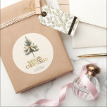 Elegant Merry Christmas Pine Tree Bow Family Classic Round Sticker<br><div class="desc">Add a festive touch to your gifts with these elegant "Merry Christmas" stickers! Featuring gold script,  a pine tree bow,  and your custom family name,  they're perfect for personalizing your holiday packages with style and warmth.</div>