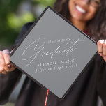 Elegant Minimalist Grey Graduation Cap Topper<br><div class="desc">Elegant graduation cap topper featuring "Graduate" displayed in a beautiful white calligraphy script with a grey background. Personalize the graduation cap topper with the graduate's name,  school name,  and graduation year.</div>