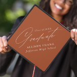 Elegant Minimalist Terracotta Graduation Cap Topper<br><div class="desc">Elegant graduation cap topper featuring "Graduate" displayed in a beautiful white calligraphy script with a terracotta background. Personalize the graduation cap topper with the graduate's name,  school name,  and graduation year.</div>