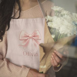 Elegant Pastel Pink Bow & Name Personalized Apron<br><div class="desc">Add a touch of elegance to your kitchen or outdoor grilling with this personalized pastel pink apron featuring a delicate bow design and your custom name. Perfect for cooking, baking, or hosting in style, this apron combines practicality with a feminine, sophisticated look. Made from durable materials, it’s ideal for everyday...</div>