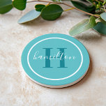 Elegant Teal Blue Round Custom Monogram Initial Coaster<br><div class="desc">Elegant round personalized beverage drink coaster design features a classic custom serif monogram initial in a teal green blue colour with your last name in modern white calligraphy script against an aqua blue coloured background. A simple white circle frames the design. Colour scheme can be customized to coordinate perfectly with...</div>