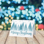 Elegant Winter Trees Custom Blue Merry Christmas Holiday Card<br><div class="desc">An elegant row of winter fir trees and snowflakes above your personalized Merry Christmas script and your family last name in pretty blue below the snow filled forest. A modern holiday card with your custom message.</div>