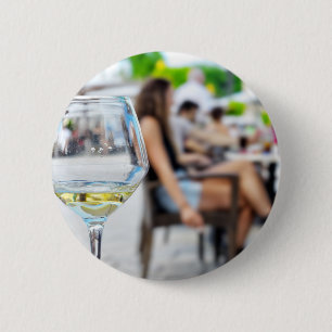 Empty glass from wine and blurred silhouettes 2 inch round button