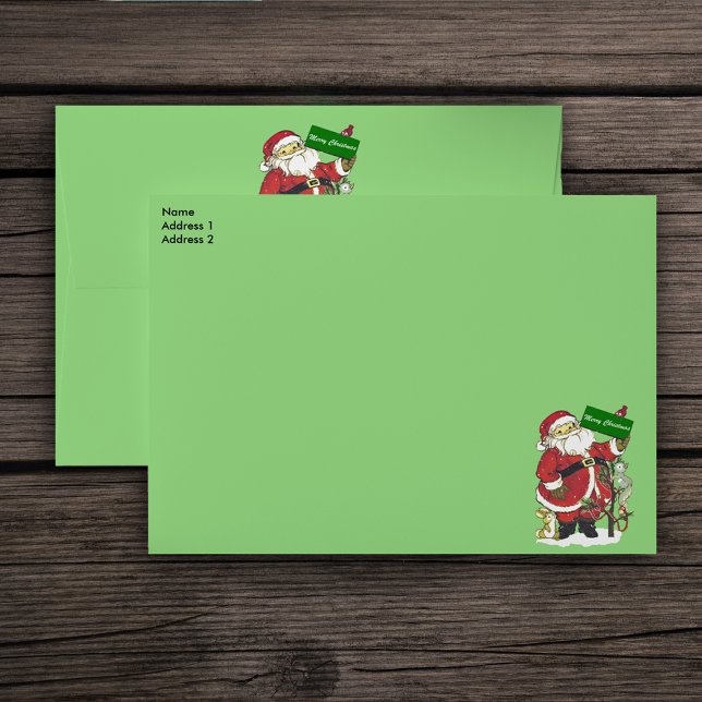 Enveloppe Joli Père Noël Animaux Joyeux Noël (Santa Clause with Merry Christmas sign surrounded by animals and tree on green mailing envelopes.)
