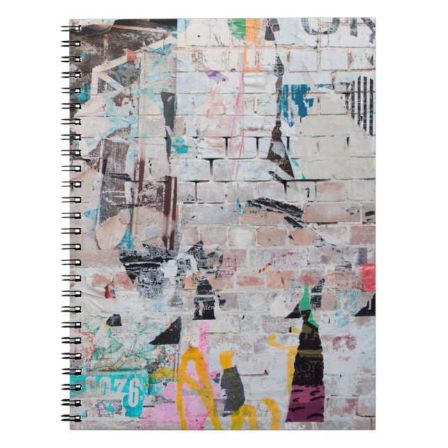 Exposed weathered brick wall with torn street post notebook (Front)