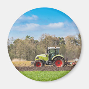 Farmer on tractor plowing sandy soil in spring magnet